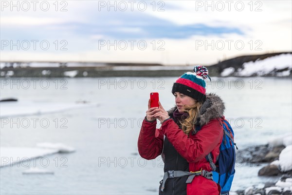 Young woman taking photo with mobile phone