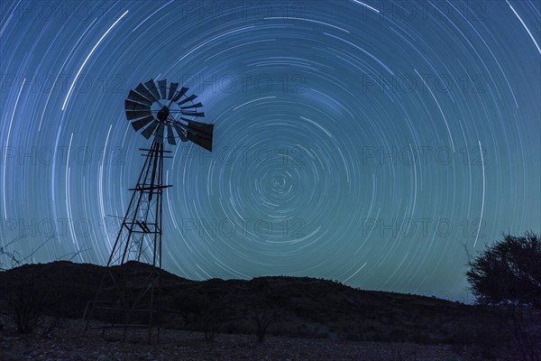 Wind pump in front of a starry sky