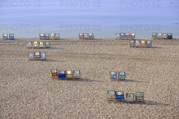 Colorful canvas chairs at the shingle beach