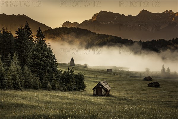 Small cabin on mountain meadow at forest edge