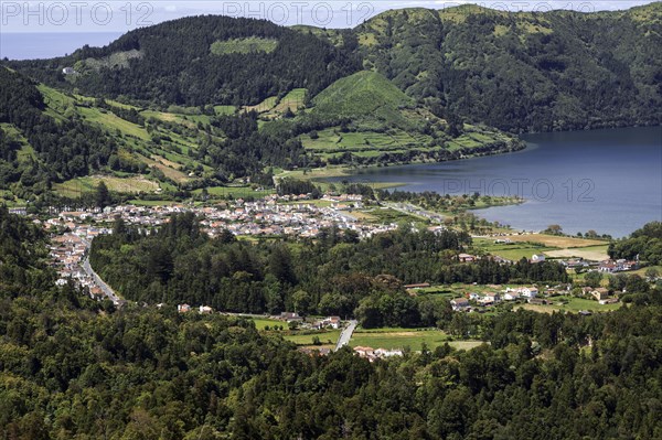 View from Miradouro da Vista do Rei into the volcanic crater Caldera Sete Cidades to the village of Sete Cidades and the crater lake Lagoa Azul