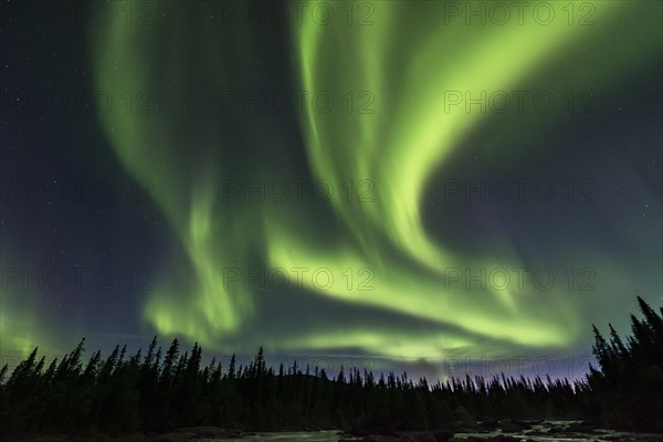 Northern Lights or Aurora Borealis above river Gamajahka or Kamajakka