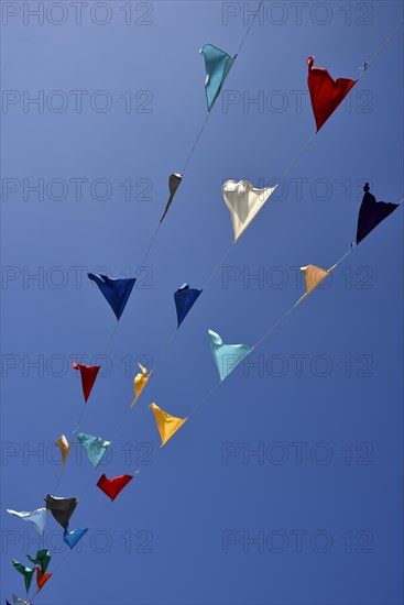 Colorful pennant against a blue sky at a festival