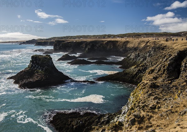 Tourists on the black cliff at Arnarstapi