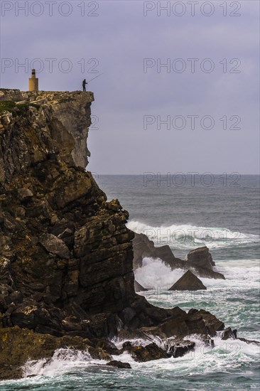 Cliff fisher at steep coast