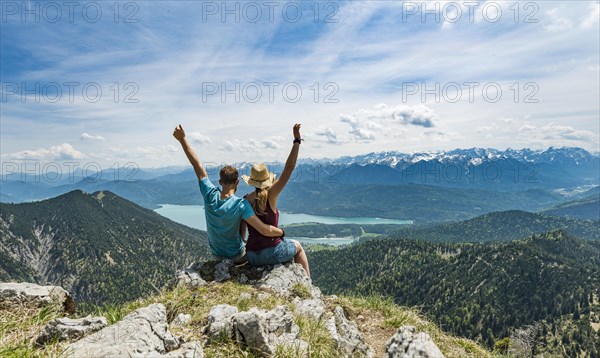 Young couple with arms in air