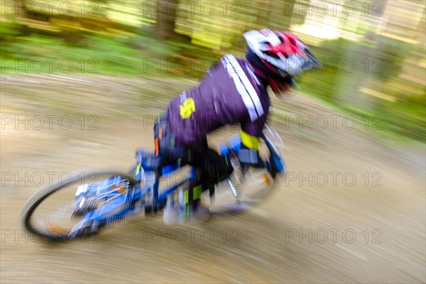 Child 9 years old rides on a mountain bike downhill