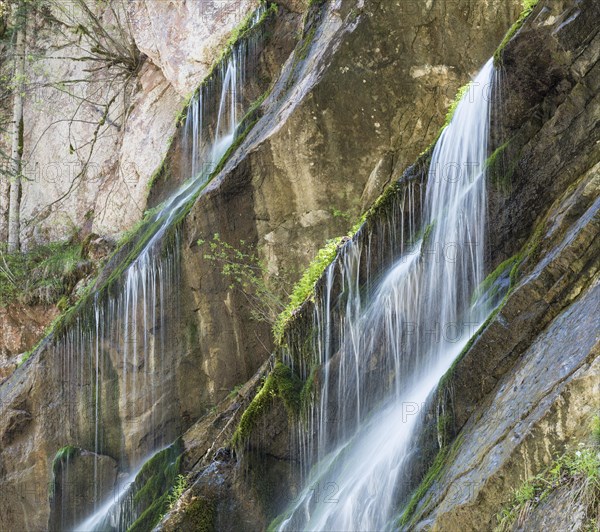 Waterfall on mossy slope in gorge