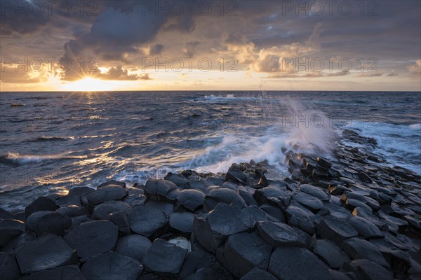 Basalt columns by the coast at sunset