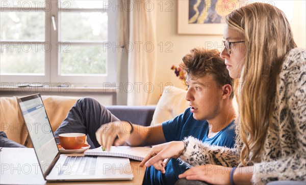 Two students sitting in front of a laptop