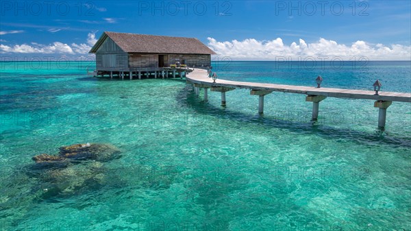 Wooden hut on stilts in lagoon