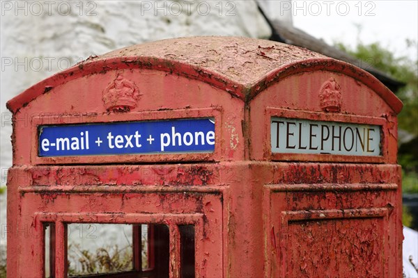 Old red telephone cell with writing e-mail + text + phone