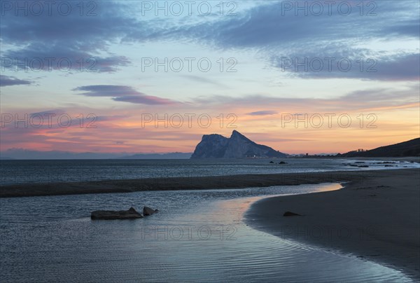 View of The Rock of Gibraltar and La Linea de la Concepcion as seen from the Mediterranean coast at sunset