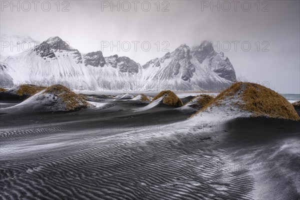 Black lava beach with fresh snow