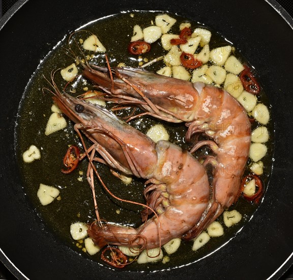 King prawns sauteeing in pan with garlic and oil