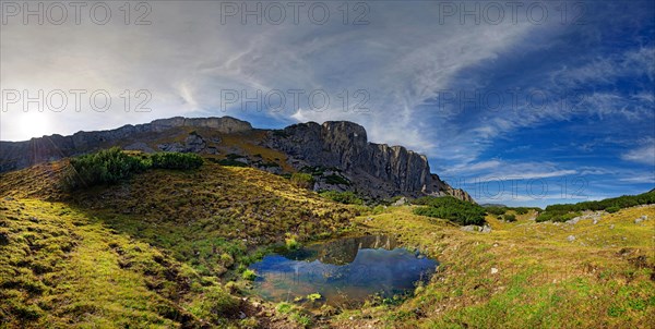 Small mountain lake with Klobenjoch north face