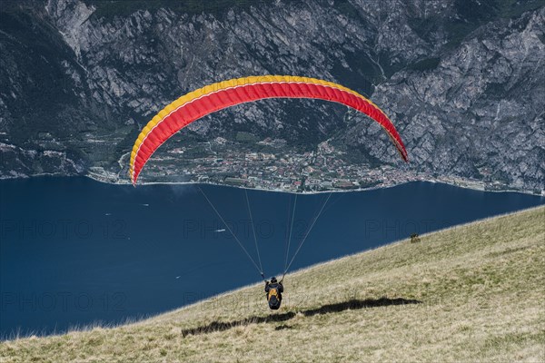 Paraglider at Monte Baldo over Lake Garda with Limone