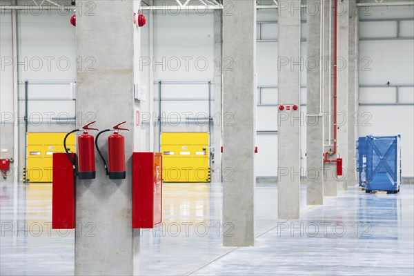 Modern empty storehouse with fire extinguishers