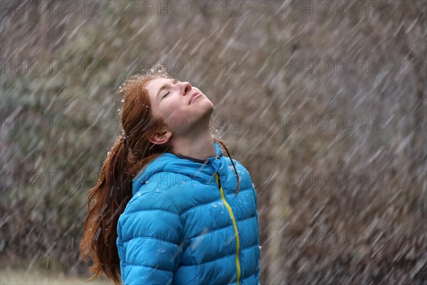 Girl enjoying thick snowflakes in winter