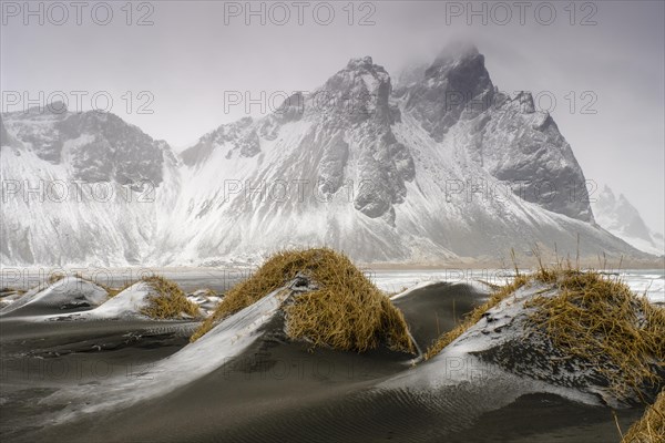 Black lava beach with fresh snow