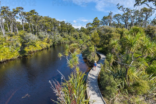 Female hiker at river with path