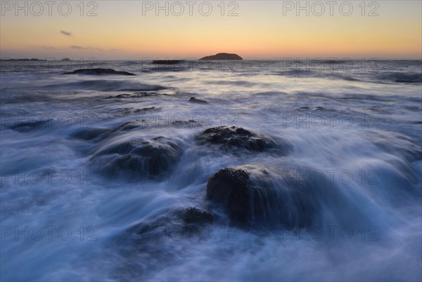 Waves washing around rocks in the ocean