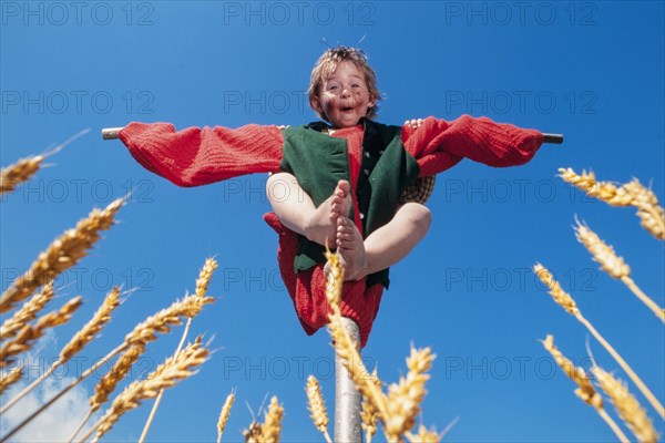 Five year old girl as a scarecrow in a cornfield