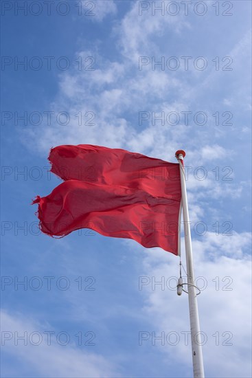 Waving red flag on the beach