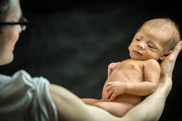 Happy father holding with love his 3 weeks old son