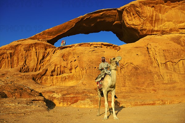 Bedouin rides his camel at Rock-Arch Al Kharza