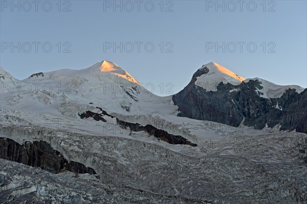 First rays of sunshine at the Castor and Pollux peaks above the border glacier
