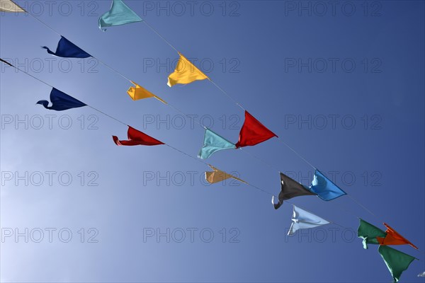 Colorful pennant against a blue sky at a festival
