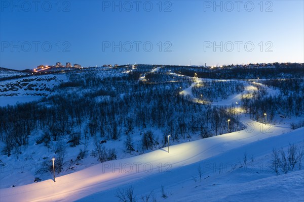 Lit cross-country ski trail at dusk