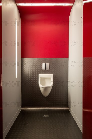 Urinal in modern public toilet nicely illuminated