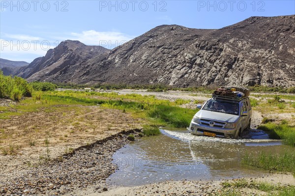 Off-road vehicle crosses Hoarusib River