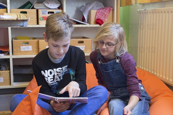 Two students in elementary school reading a book