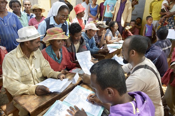 Villagers fill out applications for certification of their land on the village square