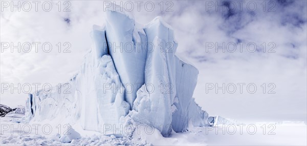 Iceberg seen from frozen fjord