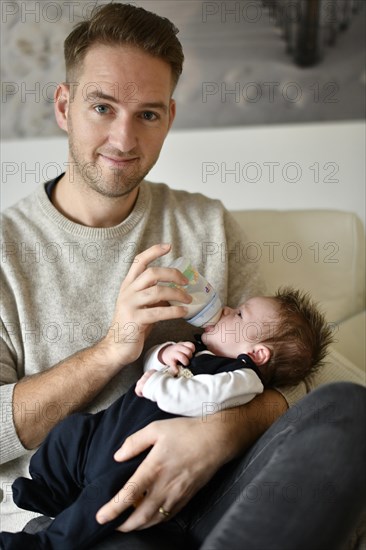 Young father feeding infant