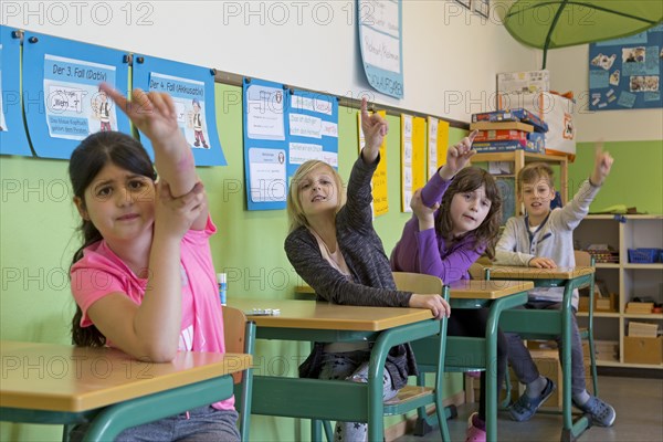 Students raising hand in the classroom