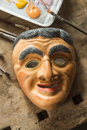 Painted wooden mask on a workbench