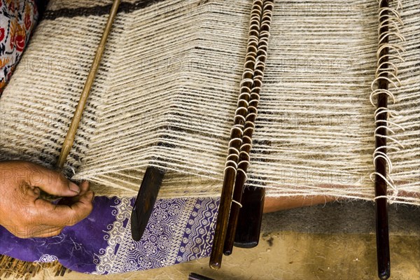 Native woman weaving blanket using sheep's wool