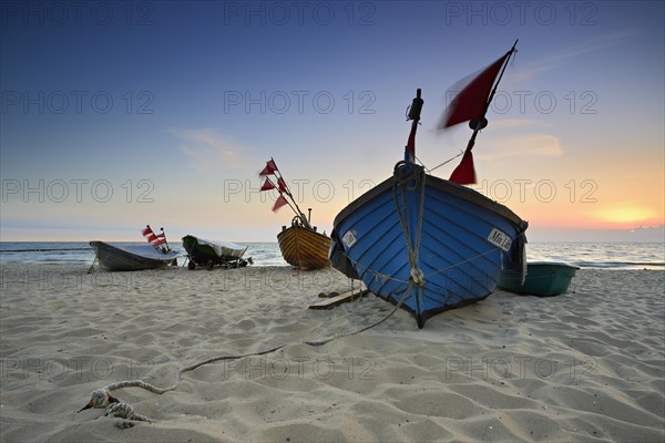 Fishing boats on beach at sunrise