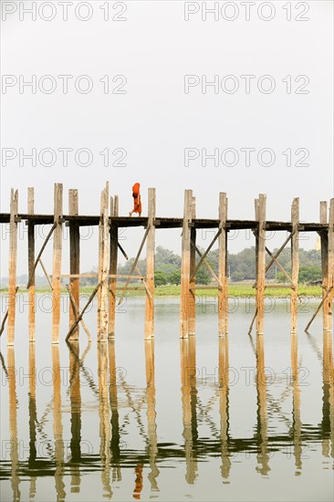 Monk crossing U Bein bridge