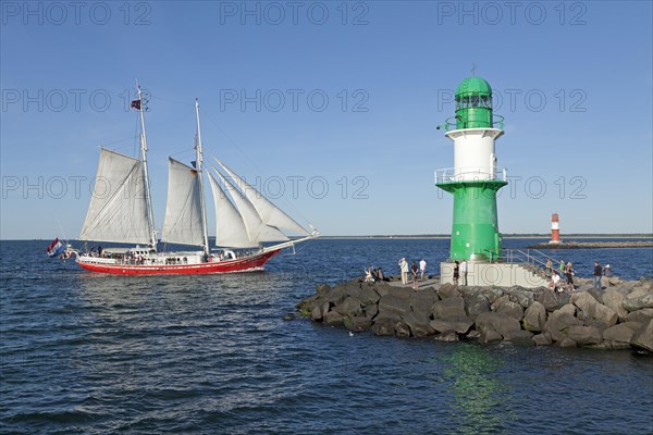 Lighthouse with sailing boat at back