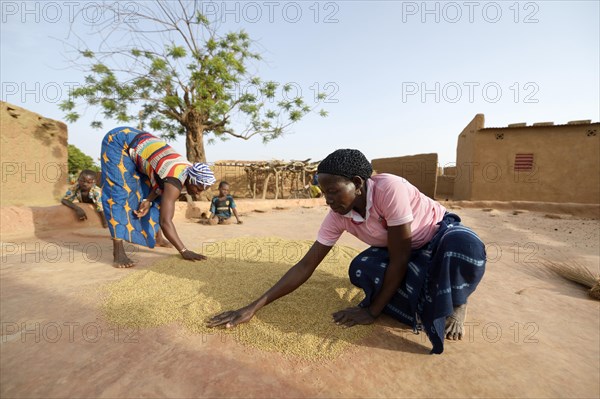 Women spreading out grain to let it dry