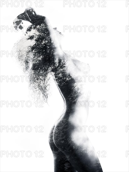 Naked woman's body with nature pattern of trees and leaves double exposed on it