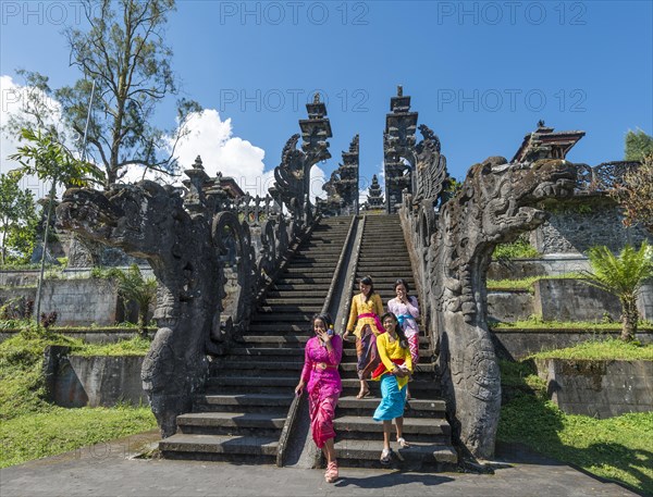 Young Balinese women descend stairs