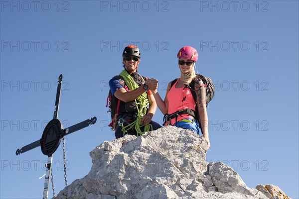 Mountain guide with a young woman at the summit of Watzmann