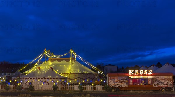 Travelling circus with counter illuminated at dusk